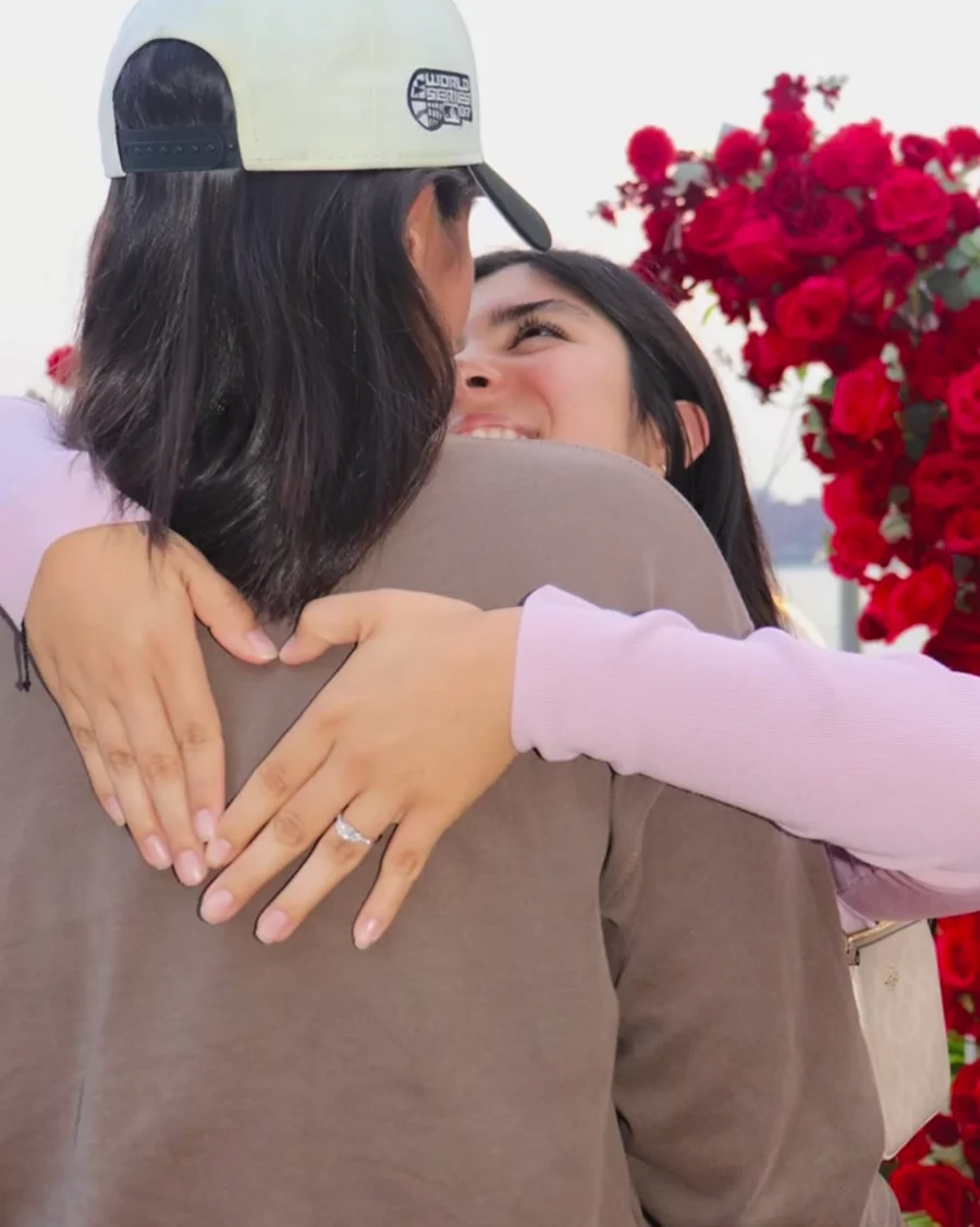 Pareja abrazada frente al arco de rosas